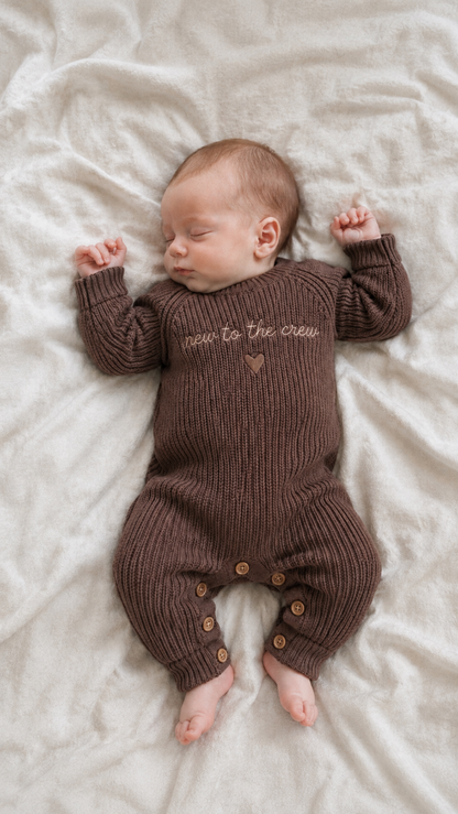 Neugeborenes Baby im braunen Strick Strampler Geschenk zur Geburt
